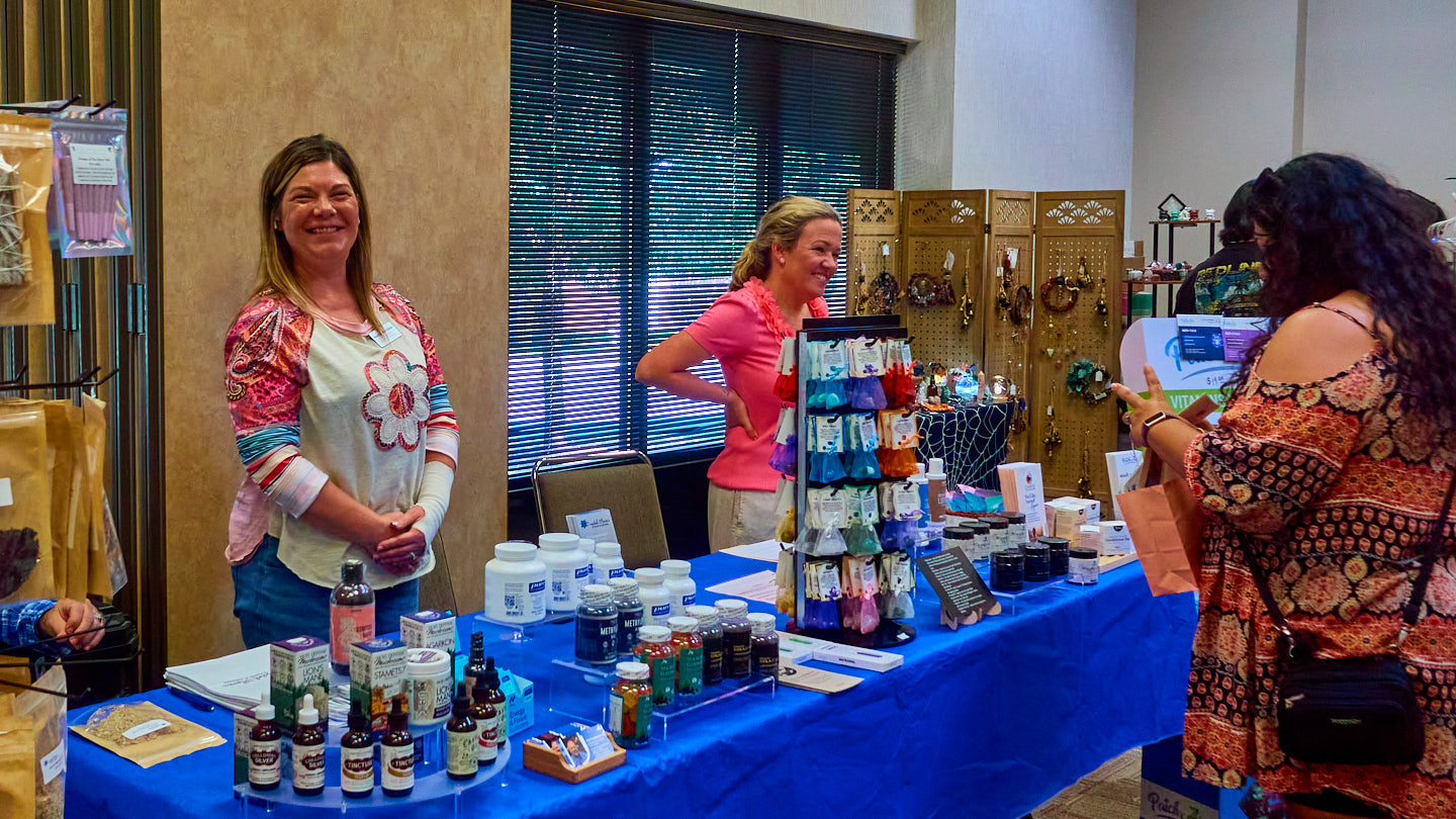 Busy vendor table with visitors and conversation at the Grapevine Wellness Expo, October 10–11, 2026.