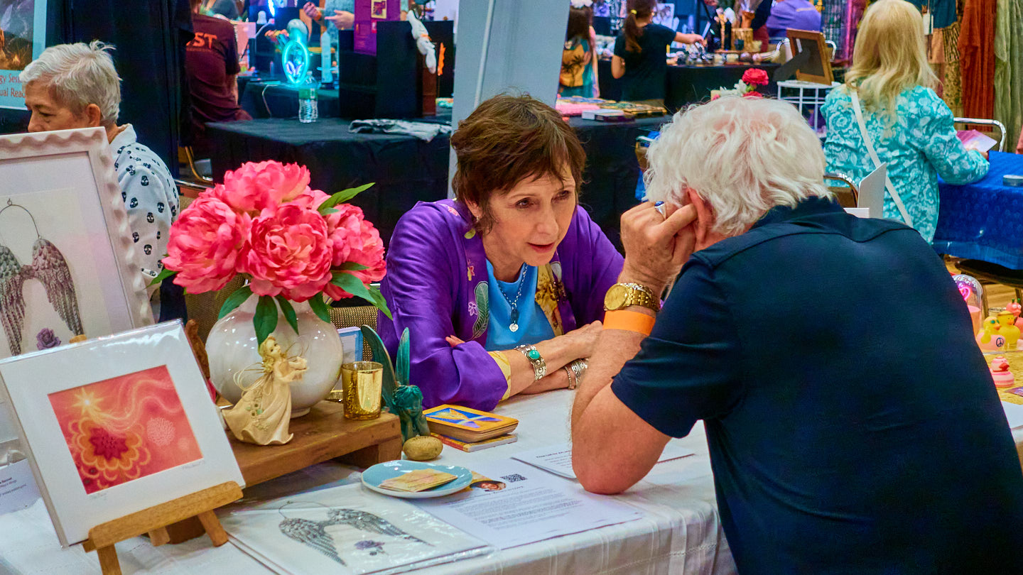 Warm conversation at a floral display at the Grapevine Wellness Expo, October 10–11, 2026.
